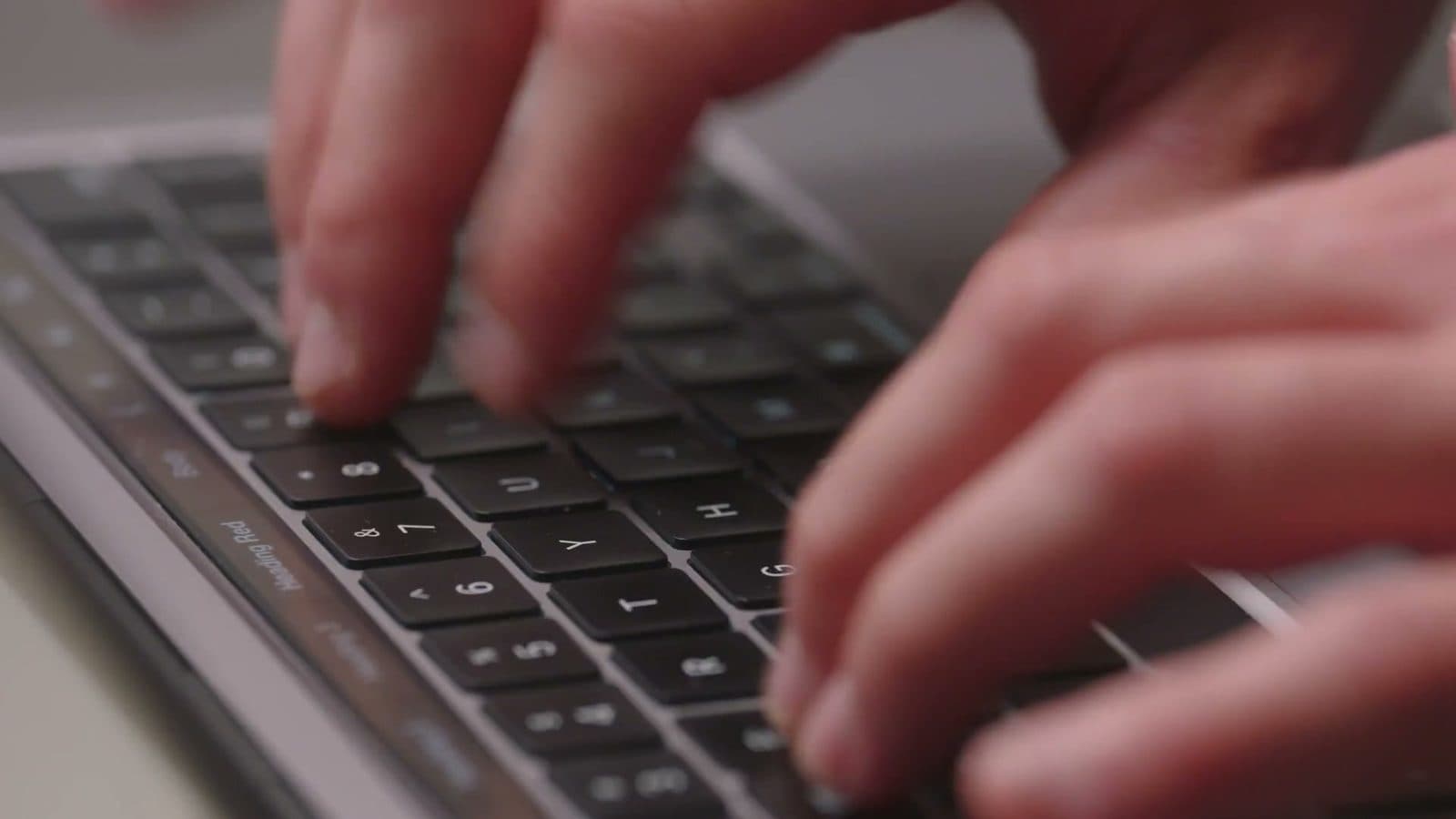 Close-up of hands typing on a laptop keyboard
